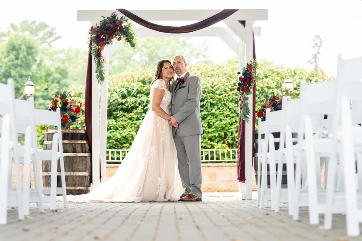 Couple under the ceremony arbor on the patio at The Club at Picatinny