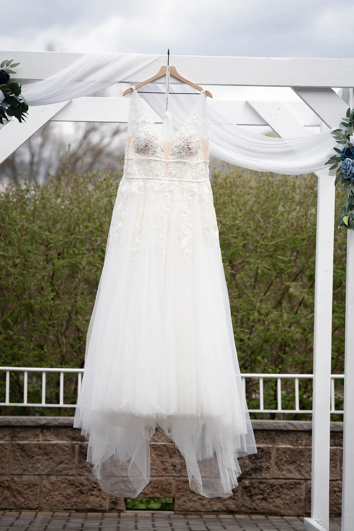 Wedding dress hanging from the ceremony arbor at The Club at Picatinny