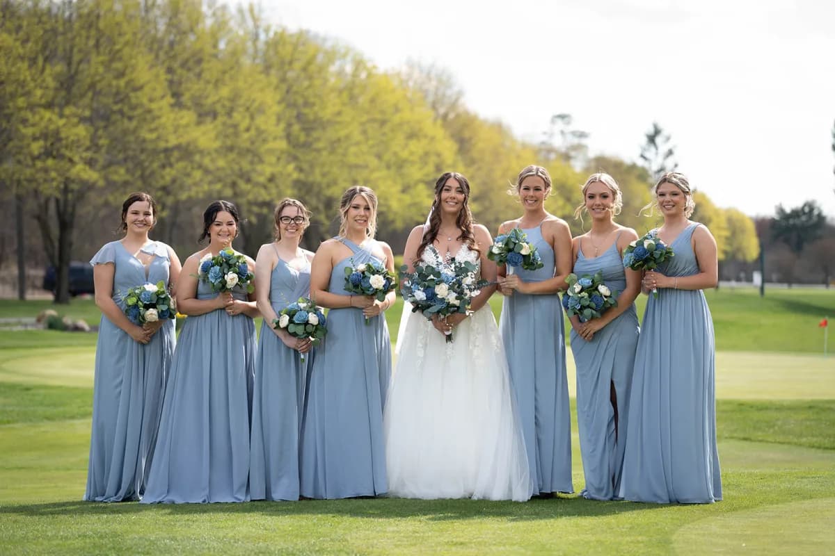 Bride with her bridesmaids in dusty-blue dresses on the lawn at The Club at Picatinny