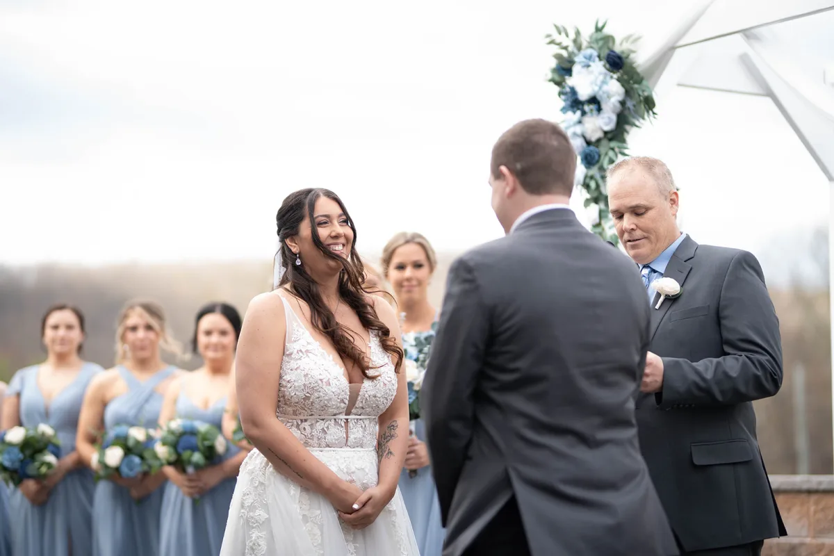 Bride and groom during the ceremony at the flower-draped arbor at The Club at Picatinny