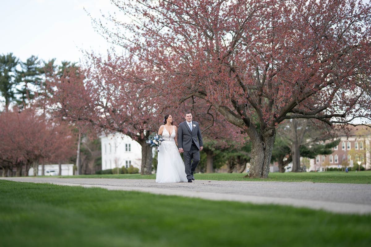 Couple walking a path under spring blossoms at The Club at Picatinny