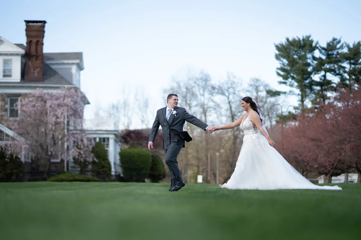 Couple walking hand in hand across the lawn at The Club at Picatinny