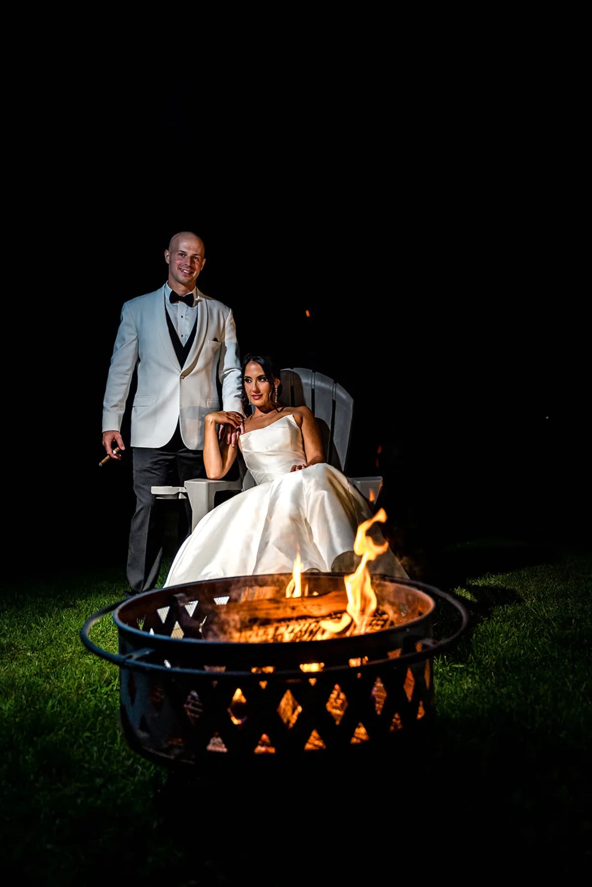 Couple beside a fire pit at night at The Club at Picatinny