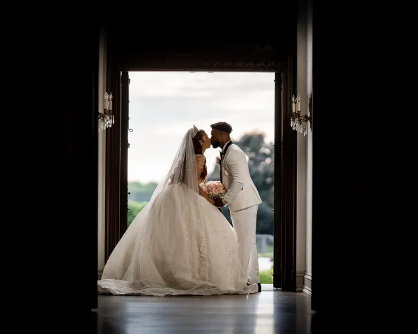 Bianca and Jeffrey kissing in a dark doorway at Park Chateau
