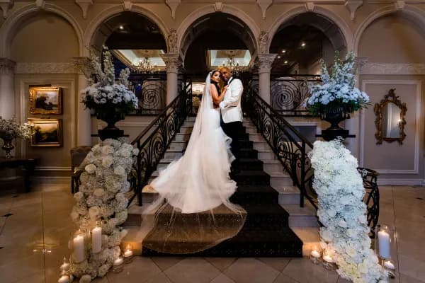 Judy and Mike at the foot of a flower-lined staircase at Nanina’s In the Park