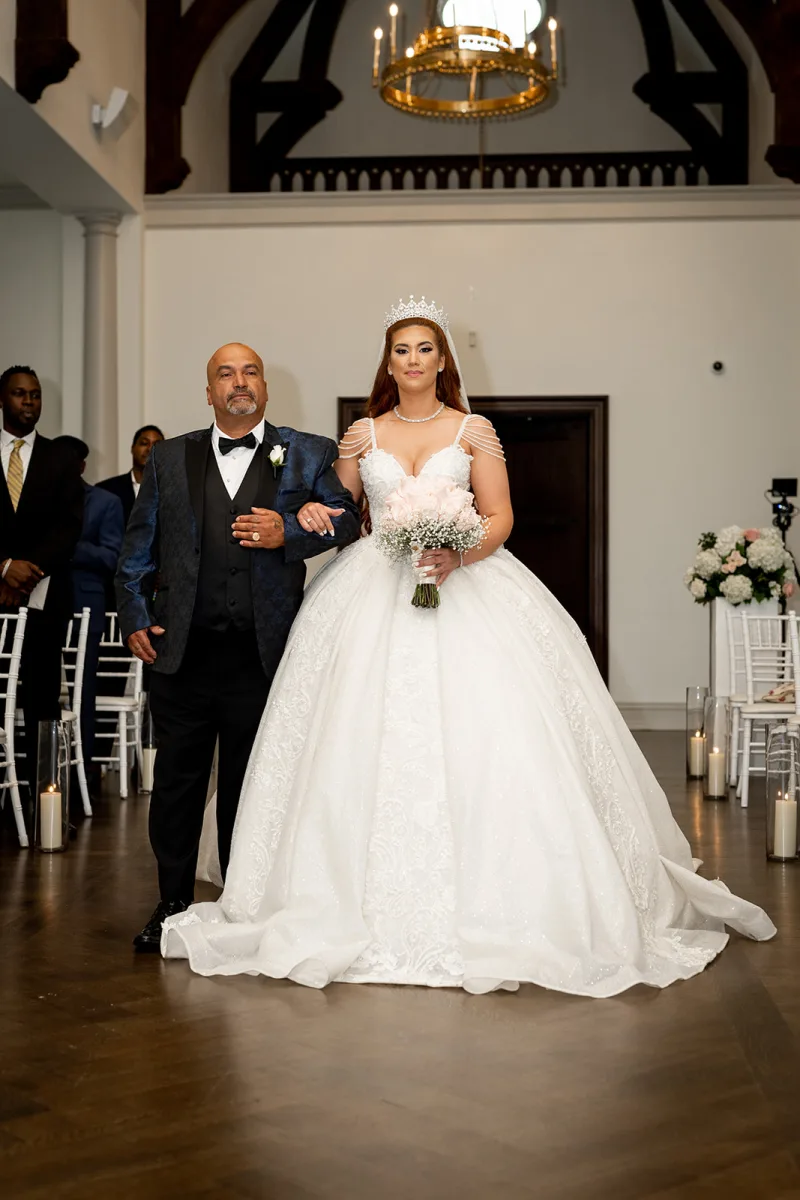 Bianca walking down the aisle on her father’s arm at Park Chateau